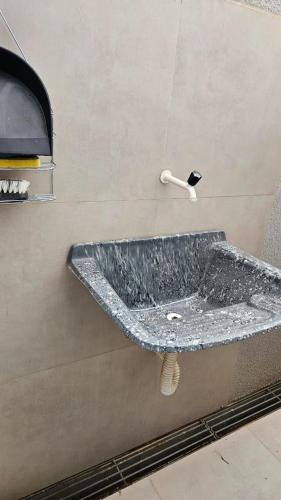 a bathroom with a stone sink on the wall at loft - studio excelente localização! in São Félix do Xingu