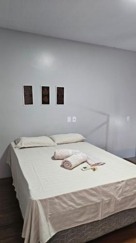 a white bed with two towels and a pair of scissors on it at loft - studio excelente localização! in São Félix do Xingu