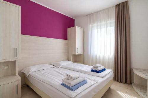 a bedroom with a bed with towels on it at Belvedere Village in Castelnuovo del Garda