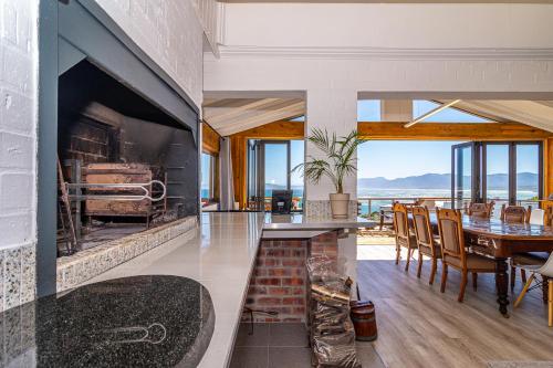 a dining room with a large fireplace in a house at Whale Heights in De Kelders