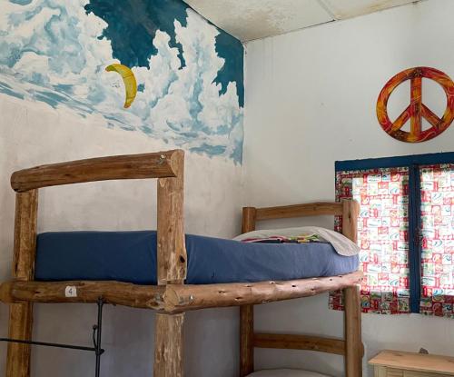 a bunk bed in a room with a painting on the wall at Rancho Lamaral Hostel & Camping in Rodeo