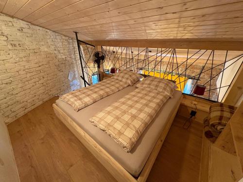 two beds in a room with a brick wall at Apartmán u Ondrika in Spišské Tomášovce
