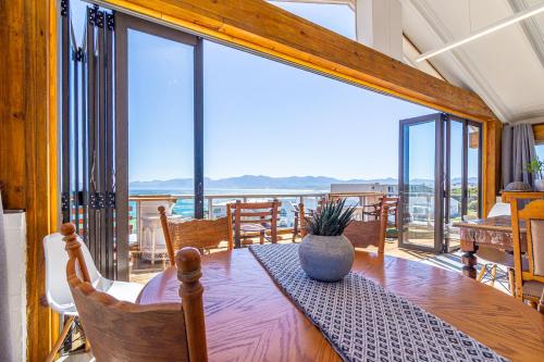 a dining room with a table and a large window at Whale Heights in De Kelders