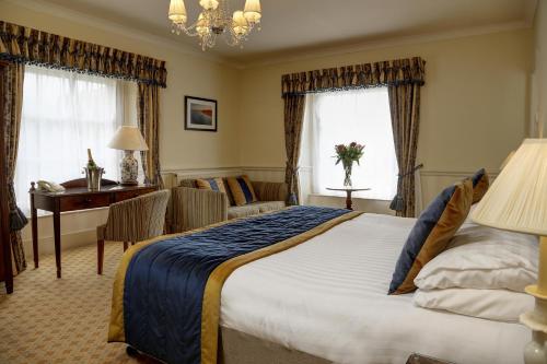 a hotel room with a large bed and a desk at Best Western Lamphey Court Hotel and Spa in Lamphey