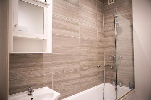 a bathroom with a shower and a sink and a tub at Flat 2 Aylesbury Street in Bletchley