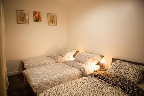 a bedroom with two beds and a lamp on the wall at Flat 2 Aylesbury Street in Bletchley