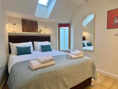 a bedroom with a large bed with towels on it at Your Space Apartments - Cambridge Place in Cambridge