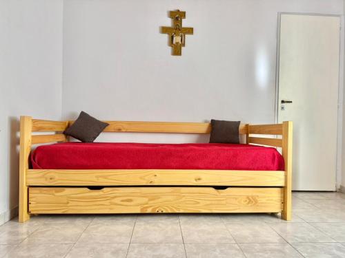 a bedroom with a wooden bed with a cross on the wall at Betania in Carhué