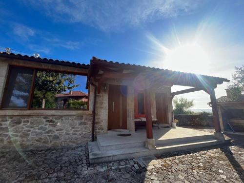 a view of a house with the sun behind it at Casa do Palheiro - Valença in Bade