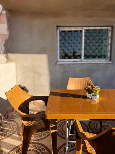 ein Holztisch mit Stühlen und ein Fenster in der Unterkunft Salem Guesthouse Experience in Al Ḩayy