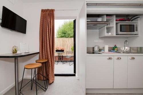 a kitchen with white cabinets and a table with a counter at Ferryman Studio Apartments in Portsmouth