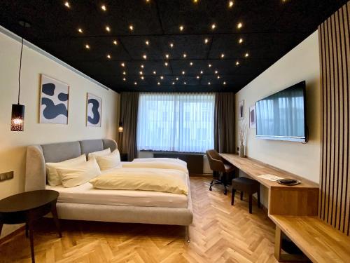 a bedroom with a bed and a table and a desk at Hotel Credé in Kassel