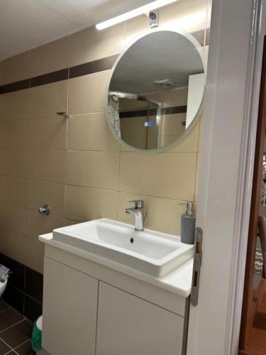 a bathroom with a white sink and a mirror at Angeligue Studio with Balcony in Ipsos