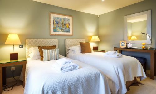 two beds in a hotel room with towels on them at Underscar - Luxury 2 Bed Apartment in Keswick