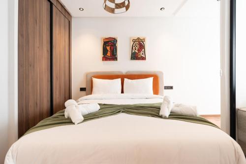 a bedroom with a large bed with white sheets at Résidence Happy Living in Casablanca