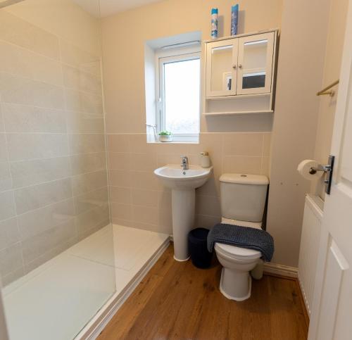 a bathroom with a toilet and a sink at Vantage Stays in Gloucestershire