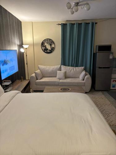 a living room with a couch and a tv at Sitati in Ruaka