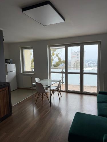 a living room with a table and chairs and windows at UniqueView Apartament Jana Pawła in Białystok