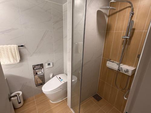 a bathroom with a toilet and a glass shower at 해변1분 숙소 광안이즘, 1 min to beach Gwangan-ism in Kwangan-dong