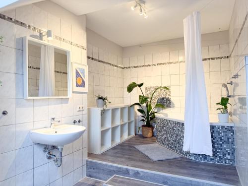 a bathroom with a sink and a tub and a shower at NEU - Gemütliches Apartment, Gruppen, Zentral in Erfurt