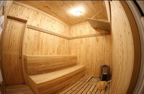 a wooden sauna with a wooden tub in a room at HOSHIとUmitoはサウナで整う完全プライベート1棟貸でプロジェクター完備 in Nakijin