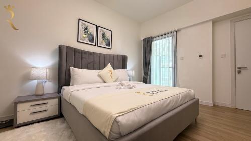 a bedroom with a large bed and a window at Cozy Poolside 1BR - Serene Luxe Chic Retreat in Abu Dhabi
