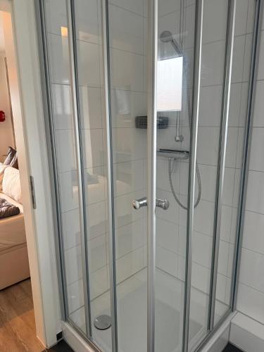 a shower with glass doors in a room at Apartment Alleestraße in Büsum