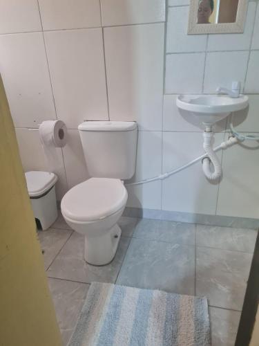 a bathroom with a toilet and a sink at Porto Pousada in Ipojuca