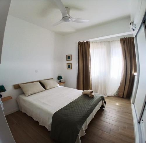 a bedroom with a bed and a ceiling fan at Avenida Dr Baltazar Lopes da Silva 33A in Mindelo