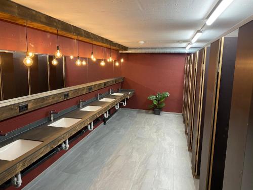 a row of sinks in a public restroom at Gruppenhaus Frutigresort in Frutigen