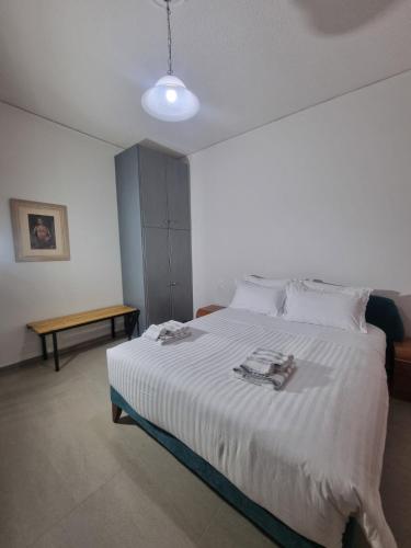 a bedroom with a white bed and a table at La Campagne Ioannina Kranoula in Ioannina