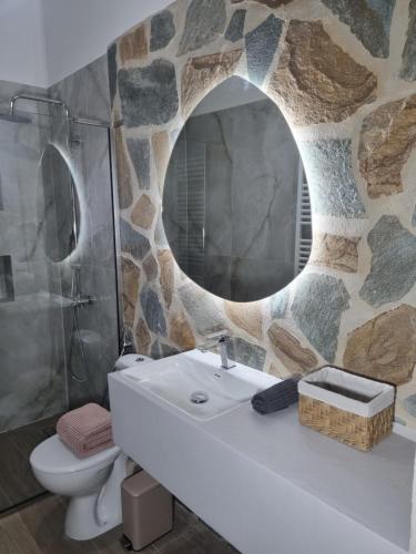 a bathroom with a sink and a stone wall at La Campagne Ioannina Kranoula in Ioannina