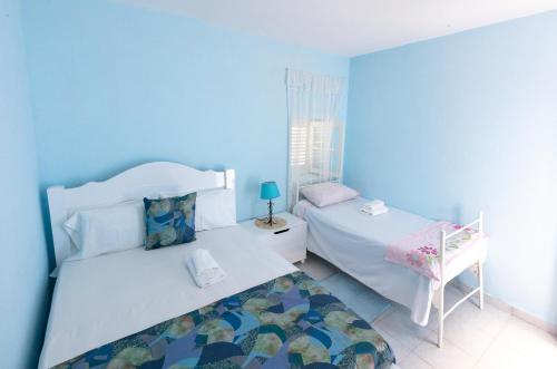 a blue bedroom with two beds and a chair at Quinta Toca do leão in Ribeira Grande