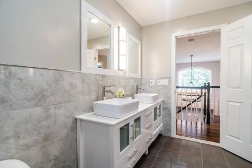 a white bathroom with two sinks and a mirror at Beautiful home next train station close to boston in Holbrook
