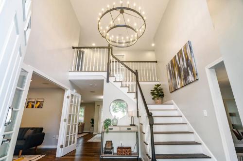 a staircase in a home with a chandelier at Beautiful home next train station close to boston in Holbrook