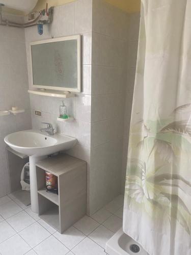 a white bathroom with a sink and a mirror at Home Room in San Pietro Avellana