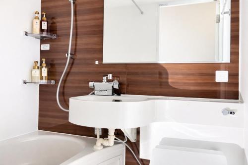 a bathroom with a white sink and a mirror at ホテルクレイドルキャビン田無 in Nishitokyo