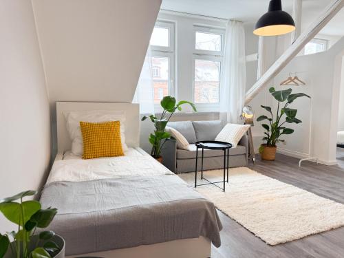 a bedroom with a bed and a chair at NEU - Gemütliches Apartment, Gruppen, Zentral in Erfurt