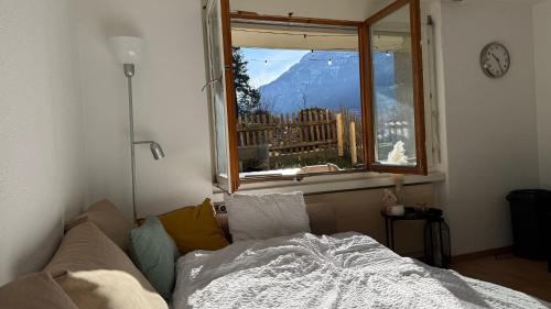 a bedroom with a bed and a window with a view at Meiringen Retreat - Sauna, Terrace & Pinball in Meiringen