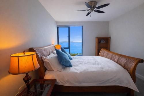 a bedroom with a bed with a ceiling fan and a window at 14 Dun Farraige in Cobh