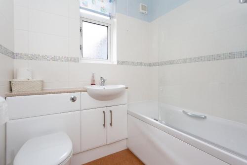 a white bathroom with a sink and a toilet at Harry Potter Studios Bungalow and Private Garden with Parking in Watford