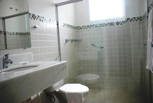 安帕羅的住宿－Grande Hotel Amparo，一间带水槽、卫生间和淋浴的浴室
