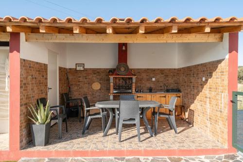 an outdoor patio with a table and chairs at Casa da Ritinha - Praia Azenhas D El Rey in Montes Juntos