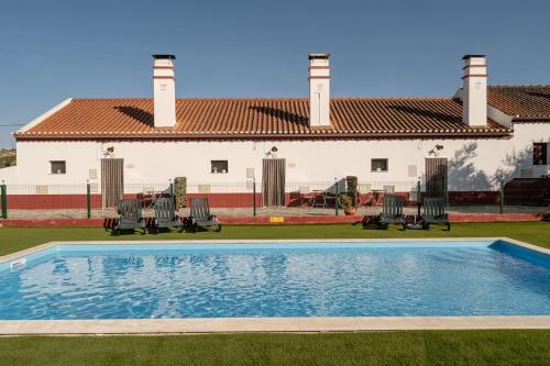 a swimming pool in front of a house at Casa da Ritinha - Praia Azenhas D El Rey in Montes Juntos