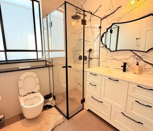 a bathroom with a toilet and a glass shower at Casa del Barone - וילה יוקרתית עם בריכה פרטית in Kefar Tavor