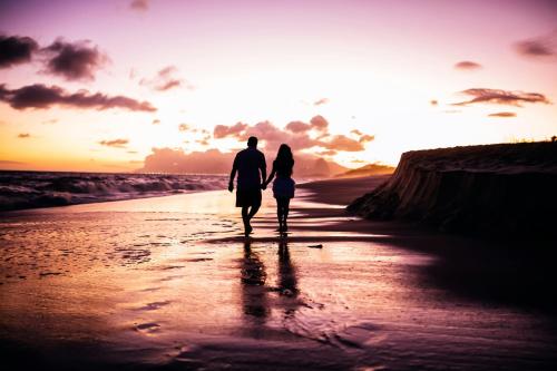 a couple walking on the beach at sunset at Fairways Guest House in Newquay