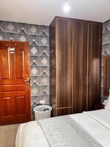a bedroom with a bed and a wooden cabinet at Serenity Homes in Ruiru