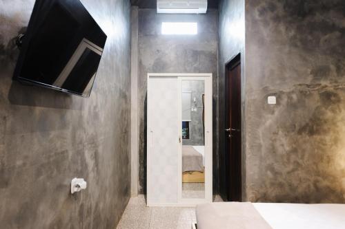 a bathroom with a tv on the wall at Urbanview Hotel Syariah Keys Banjarmasin by RedDoorz in Terantang
