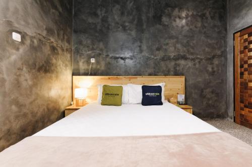 a bedroom with a large white bed with two pillows at Urbanview Hotel Syariah Keys Banjarmasin by RedDoorz in Terantang