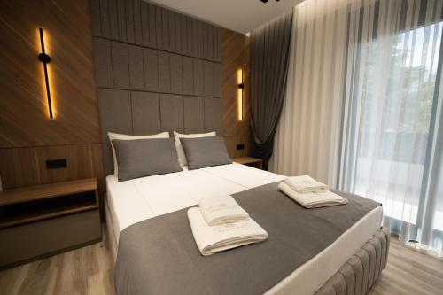 a bedroom with a large bed with two towels on it at Sunset Luxury Apartments in Keramoti